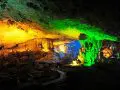 Colorful illuminated limestone formations inside a cave.